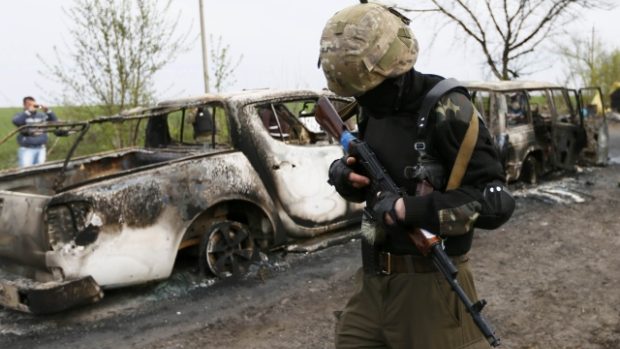 Proruský separatista hlídkuje nedaleko kontrolního stanoviště, kde došlo k přestřelce (Ukrajina, Slavjansk)