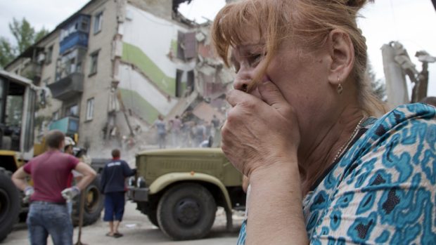 Žena pláče před domem, kde žila, který byl vybombardován při leteckém útoku na město Snižne na východě Ukrajiny (15. července 2014)