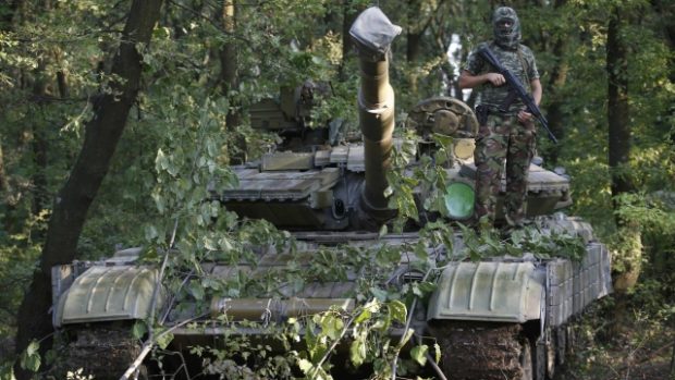 Proruský separatista pózuje na tanku ruské výroby T-64 v Doněcku na východě Ukrajiny