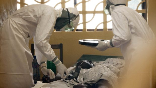 Americký lékař Kent Brantly (vlevo) ošetřuje pacienta s ebolou v nemocnici v Monrovii. Později se virem sám nakazil