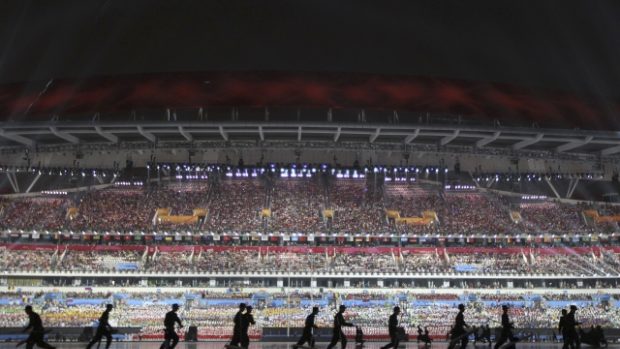 Čínští vojáci suší plochu stadionu během zahajovacího ceremoniálu olympijských her mládeže