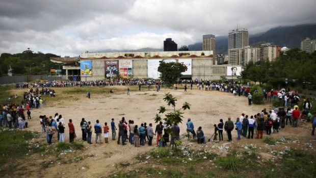 Lidé stojí Bicentenario forntu před státem provozovaným supermarketem Bicentenario v Caracasu