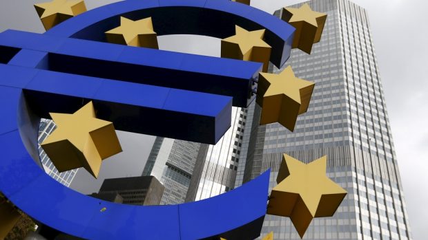 Symbol eura, v pozadí sídlo ECB ve Frankfurtu (ilustrační foto)