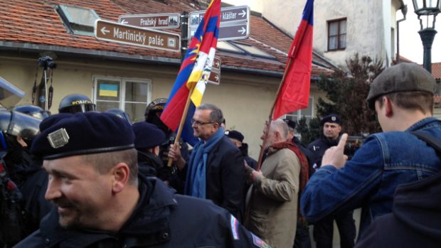 Poslanec TOP 09 Miroslav Kalousek s tibetskou vlajkou (vlevo) a europoslanec Jaromír Štětina s českou vlajkou se snaží projít skrz zástup policistů na protestní akci