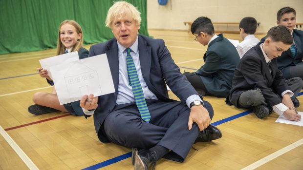 Britský premiér Boris Johnson mezi žáky ve školní tělocvičně ve městě Coalville