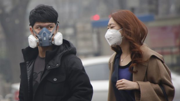 Lidé v Pekingu nosí kvůli smogu ochranné masky (archivní foto)