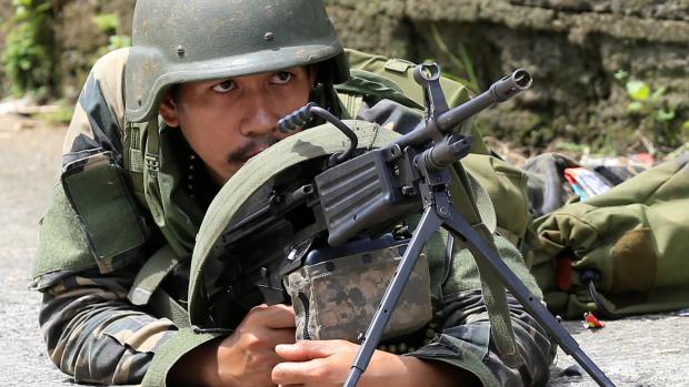 Vládní voják zaměřuje cíl (Marawi, jižní Filipíny).