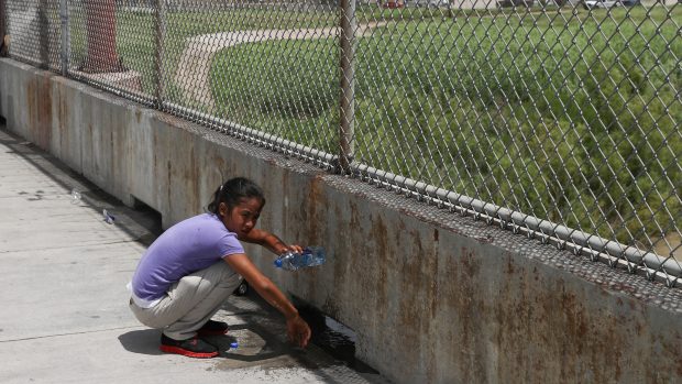 Dívka z Hondurasu čeká na mexické straně mezinárodního mostu Brownsville-Matamoros poté, co byl její rodině znemožněn vstup do USA.