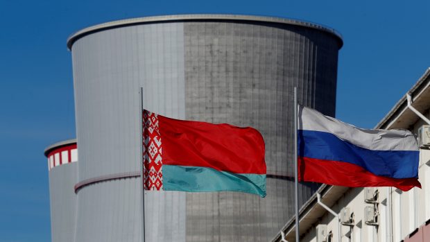 Běloruská a ruská státní vlajka před rozestavěnou jadernou elektrárnou v Ostrovci