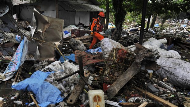 Záchranář prohledávající trosky po tsunami, která zpustošila indonéské pobřeží Sundského průlivu