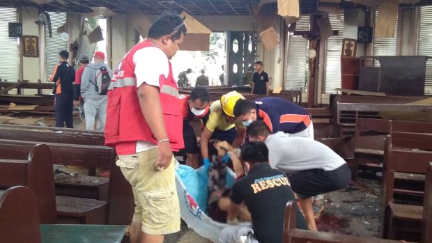 Členové Červeného kříže se starají o zraněné po bombovém útoku v Jolo.