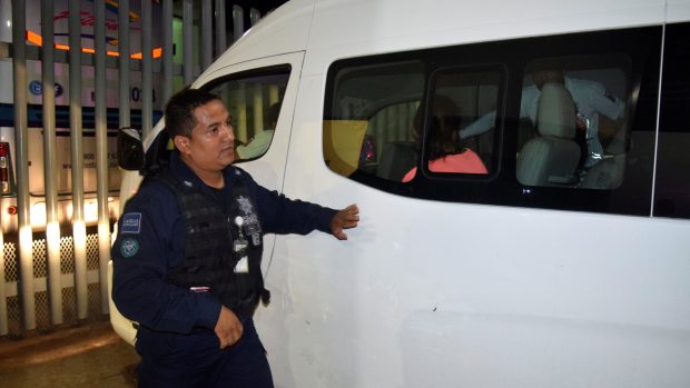 Mexický policista kontroluje zadržené migranty, kteří uprchli z detenčního zařízení