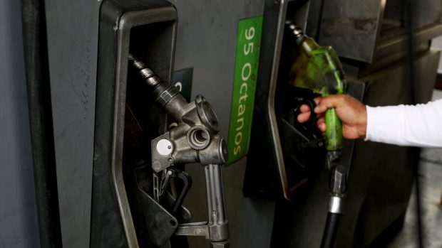 Venezuelu trápí nedostatek benzinu. Muž tankuje pohonné hmoty u benzínové pumpy v metropoli Caracasu