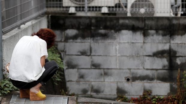 Lidé truchlí před budovou Kyoto Animation, která se stala terčem útoku žháře