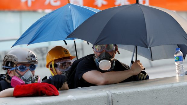 Protestující v centru Hongkongu se kryjí za rozevřenými deštníky