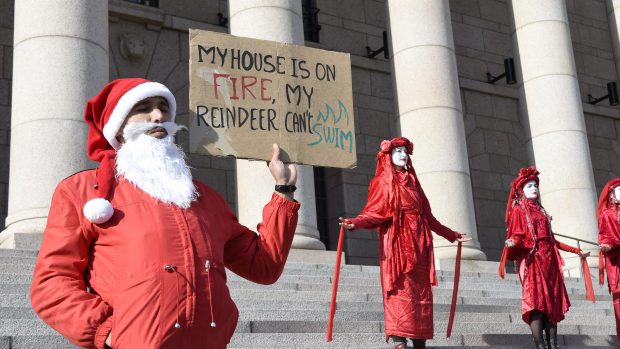 „Můj dům hoří, moji sobi neumějí plavat.“ Muž v kostýmu Santa Clause na protestu ve Finsku.