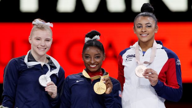 Simone Bilesová se zlatou medailí (uprostřed). Vlevo stříbrná Američanka Jade Careyová, vpravo Britka Elissa Downieová s bronzem.