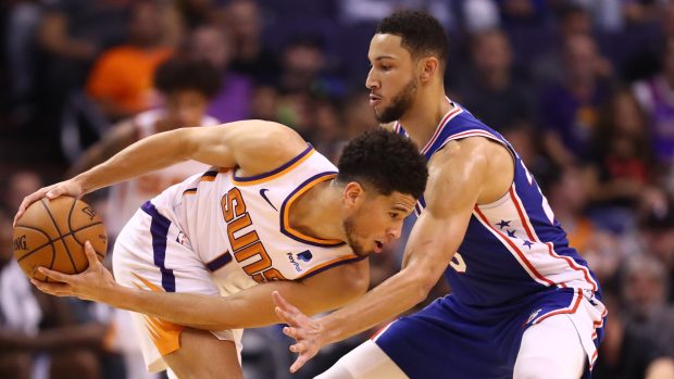 Ben Simmons z týmu NBA Philadelphia 76ers brání Devina Bookera z týmu Phoenix Suns