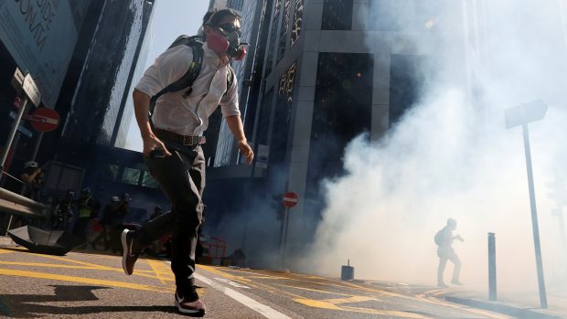 Protestující v Hongkongu utíkají poté, co policie v ulicích použila slzný plyn. Fotografie z 11. listopadu 2019