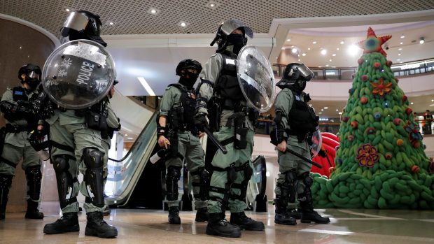 Policisté zasahují proti protivládním demonstrantům protestujícím na Štědrý den nákupním středisku v Hongkongu.