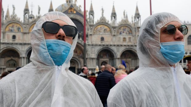Někteří návštěvníci na náměstí sv. Marka se oblékli do ochranných obleků. Sever Itálie hlásí největší počet nakažených koronavirem v Evropě.