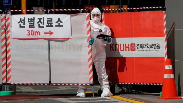 Zdravotní pracovník u brány místa testování na koronavirus v jihokorejském městě Tegu