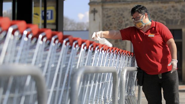 Pracovník supermarketu dezinfikuje nákupní vozíky ve Světlé nad Sázavou.