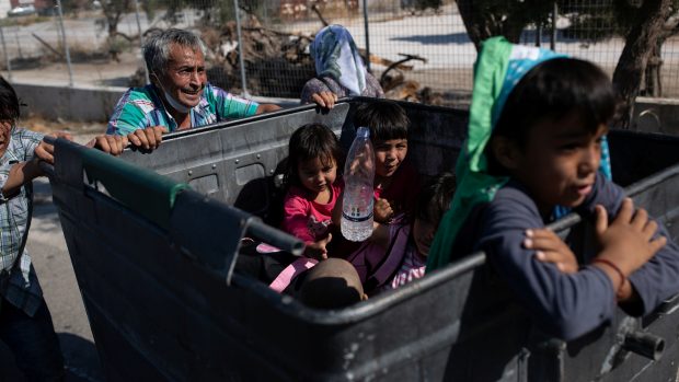 Dva muži tlačí popelnici se svým majetkem a dětmi (foto z 11. září z řeckého ostrova Lesbos)