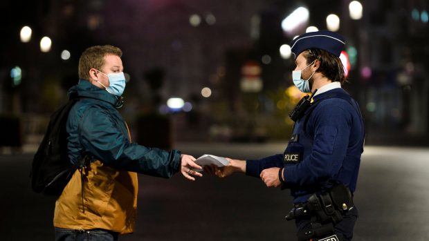 Belgický policista kontroluje muže v Bruselu.