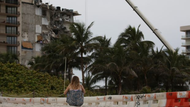 Žena sedící před zhroucenou budovou v Miami