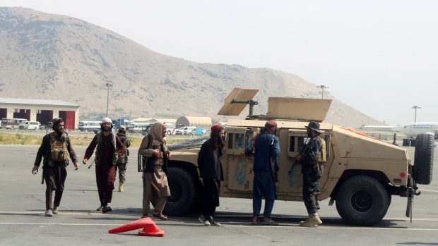 Tálibánci si prohlížejí jeden z opuštěných vozů Humvee