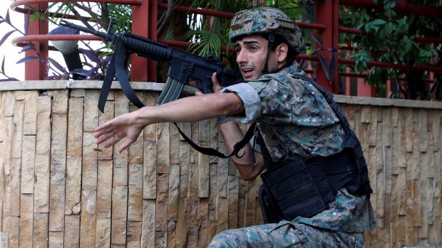 Voják gestikuluje při střelbě na protestu v Bejrútu