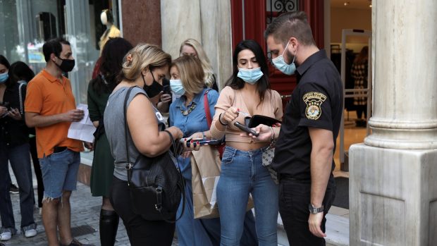 Bezpečnostní služba kontroluje doklad o bezinfekčnosti před řeckou restaurací