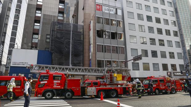 Hasiči před budovou v japonské Ósace, při jejímž požáru zemřelo 27 lidí