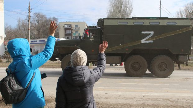 Lidé v krymském městě Armjansk mávají ruskému armádnímu vozidlu