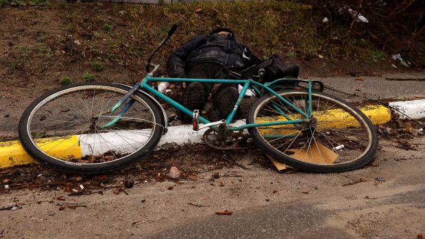 Mrtvý cyklista na ulici ukrajinského města Buča