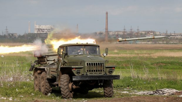 Příslušníci proruských jednotek odpalují vícenásobný raketový odpalovací systém BM-21 Grad během bojů poblíž závodu Azovstal v Mariupolu