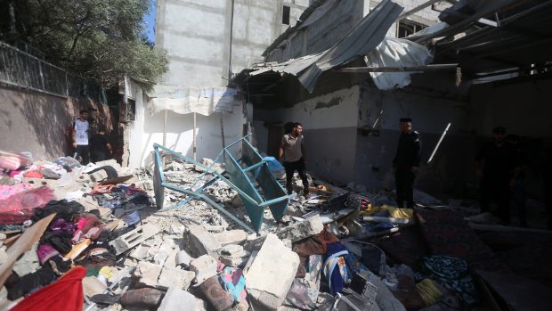 Muži prohledávají sutiny domu zasaženého při izraelském leteckém útoku v severním pásmu Gazy