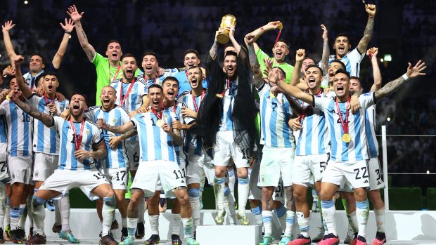 Lionel Messi zvedá se spoluhráči trofej pro mistry světa. Pro Argentinu je to první titul od roku 1986 a celkově třetí v historii