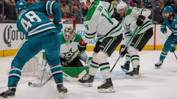 Brankář Dallas Stars Jake Oettinger zasahuje proti centru San Jose Sharks Tomáši Hertlovi