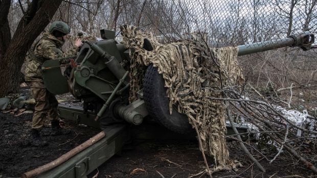 Příslušník ukrajinské armády se připravuje na střelbu z houfnice na frontové linii u Bachmutu