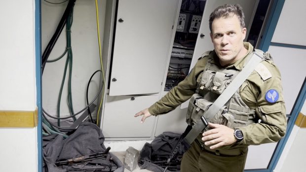 Izraelský voják ukazuje na zbraně, které se podle armnády nacházely v nemocnici Šífa
