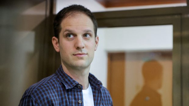 Reportér deníku Wall Street Journal Evan Gershkovich stojí v ohradě pro obžalované před soudním jednáním