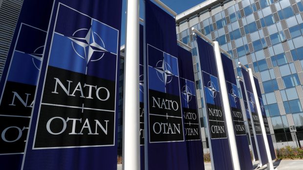 Transparenty s logem NATO jsou umístěny u vchodu do nového sídla NATO během stěhování do nové budovy v Bruselu