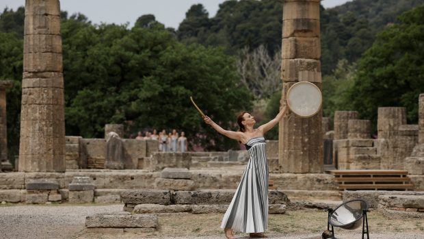 Kněžka úderem do bubínku zahajuje ceremoniál slavnostního zapálení olympijského ohně