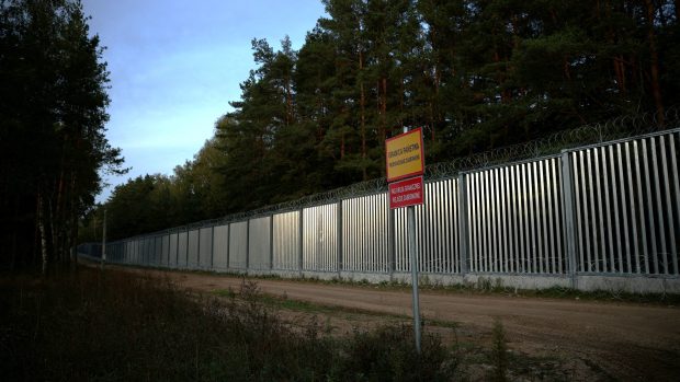 Celkový pohled na plot na polsko-běloruské hranici při západu slunce během migrační krize v polském městě Opaka Duza, 3. října 2023