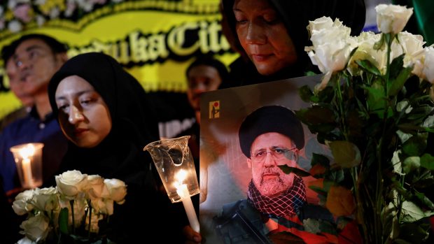 Žena s fotografií zesnulého íránského prezidenta Ebrahima Raisiho se účastní vigilie k uctění jeho památky a památky dalších obětí, které zahynuly při havárii vrtulníku, před íránským velvyslanectvím v Jakartě, 20. května