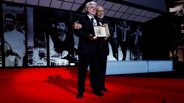 Režisér George Lucas pózuje vedle Francise Forda Coppoly poté, co byl oceněn čestnou Zlatou palmou během závěrečného ceremoniálu 77. filmového festivalu v Cannes v Cannes