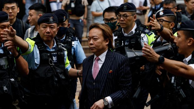 Lawrence Lau Wai-chung je doprovázen policií před budovu soudu v Západním Kowloonu poté, co byl 30. května zproštěn obvinění podle zákona o národní bezpečnosti