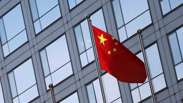 Čínská vlajka před budovou Čínské komise pro regulaci cenných papírů (CSRC) na Finanční ulici v Pekingu 8. února 2024